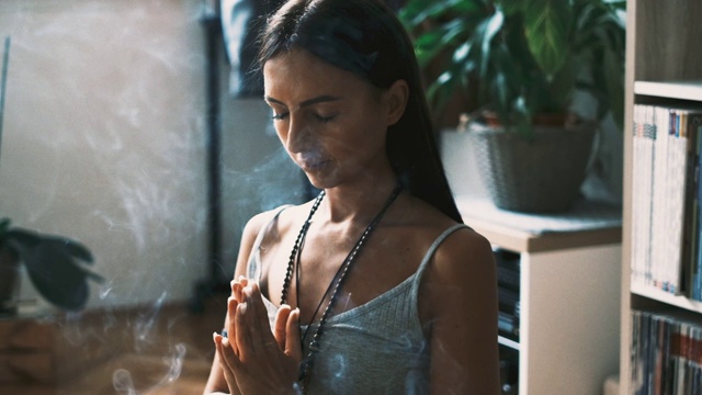 一个女性瑜伽修行者沉思和放松与香在家里视频下载