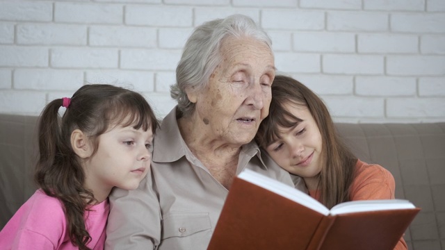 奶奶和孙女在看书。视频素材