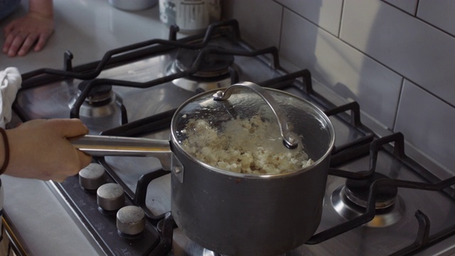 单片机，稳定手持-母亲和女儿在锅中制作爆米花视频素材