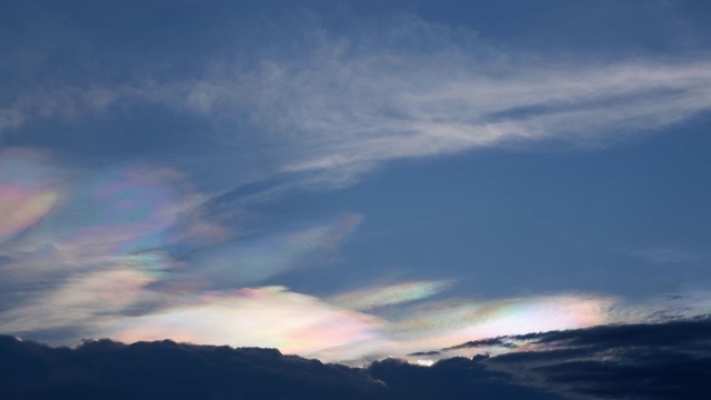 美丽的彩虹云之上的乌云快速移动在天空在晚上。视频下载
