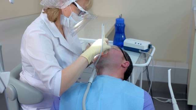 牙科医生用超声波清洗牙齿的病人。视频素材