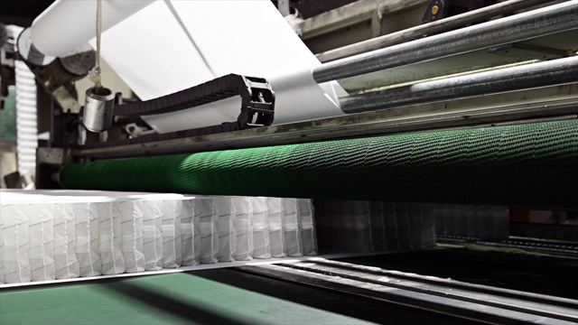 机器运输一套独立的弹簧块，输送带用于生产床垫弹簧，视频素材