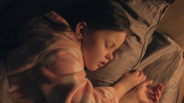 睡觉的孩子放松的女孩甜美的梦，床上的夜晚视频素材