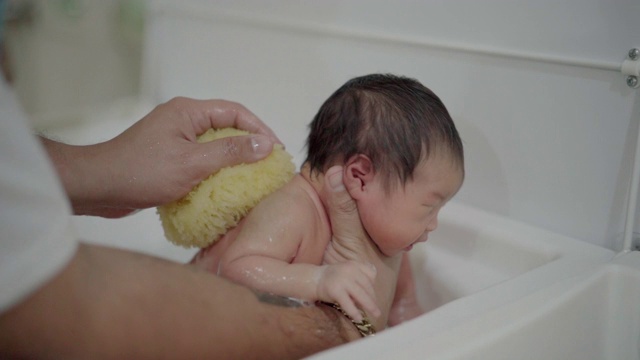 父亲正在给她的新生儿洗澡视频素材