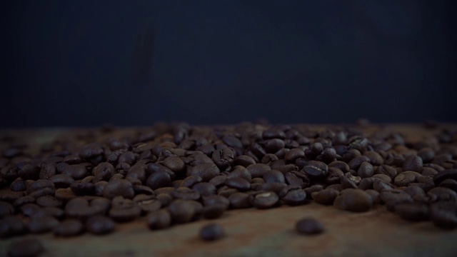 咖啡豆落在黑色背景上的慢镜头视频素材