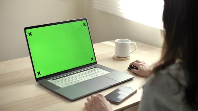 一个女人使用绿色模拟屏幕笔记本电脑的特写视频素材
