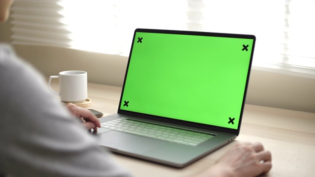 一个女人使用绿色模拟屏幕笔记本电脑的特写视频下载
