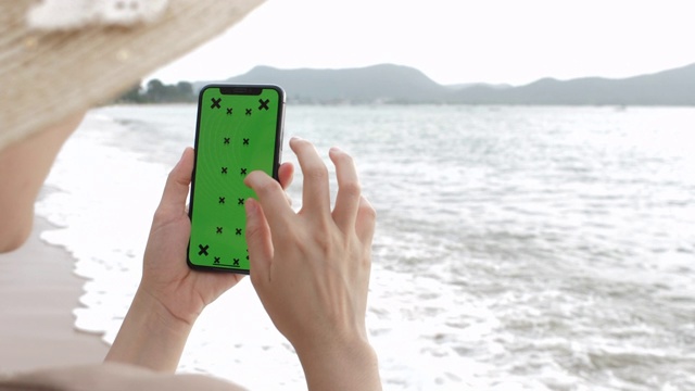 在度假中使用绿屏手机的女人视频素材