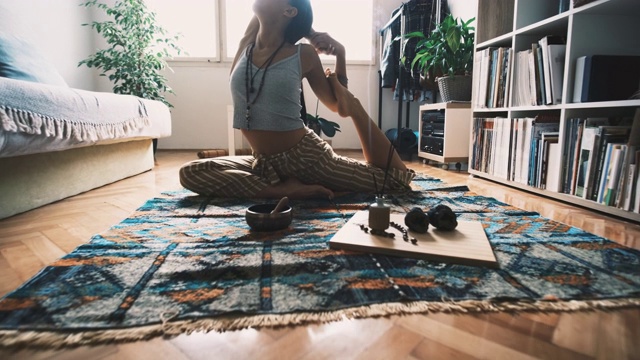 年轻女子做美人鱼瑜伽姿势和放松在家里视频下载