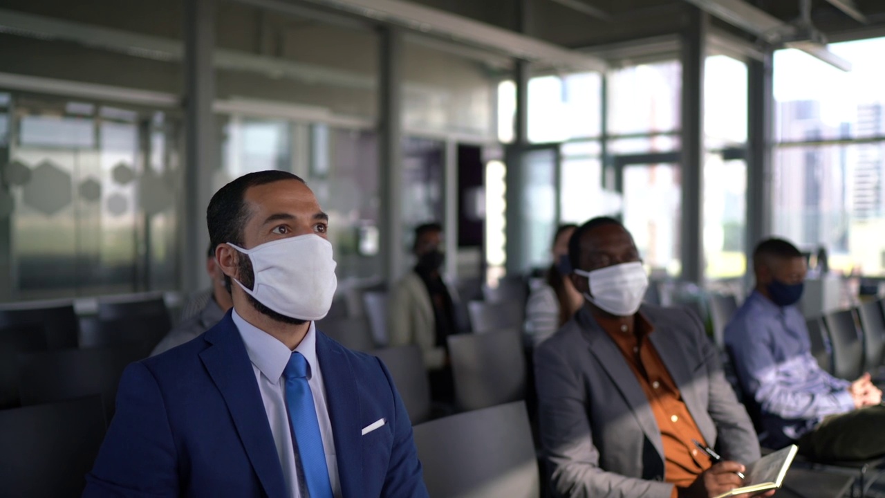 商务人士参加研讨会时要保持社交距离，戴上口罩视频素材
