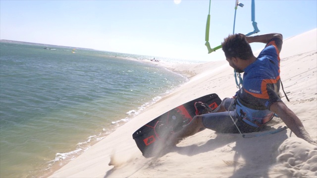 男子风筝滑板上的一个沙丘风筝板附近的海滩。视频下载