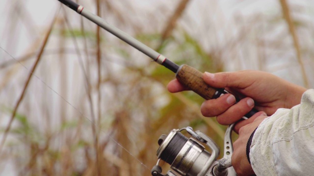 渔夫在秋天钓梭子鱼时，用旋转的卷线来布线视频素材