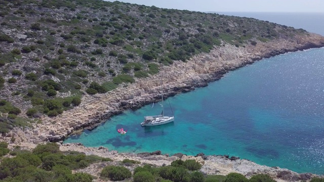 一艘帆船停泊在希腊斯基亚索斯的V形海湾的无人机图片。视频素材