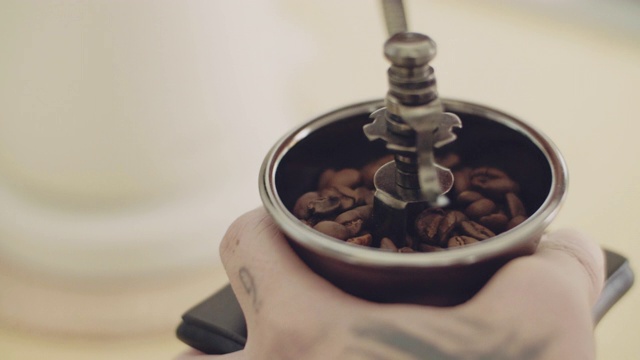 手用咖啡研磨机的年轻亚洲男子视频下载