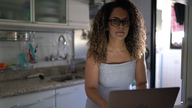 一个成熟女人用笔记本电脑在家工作的肖像视频素材