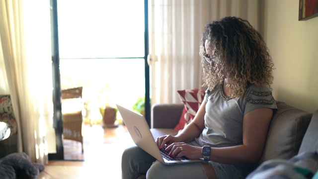 一个使用笔记本电脑在家工作的女人的肖像视频素材