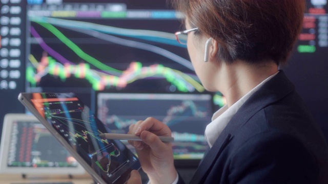 女人看着屏幕上的股票市场数据视频素材