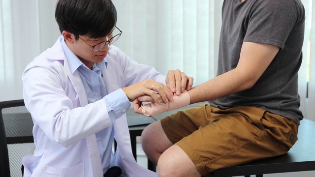 亚洲理疗师正在检查患者手腕手术的结果。视频素材