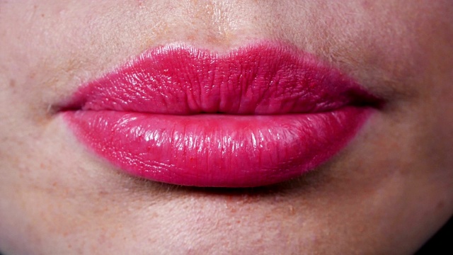 女人的嘴唇美丽，嘴唇撅着。丰满的嘴唇，洁白美丽的牙齿的特写。视频素材