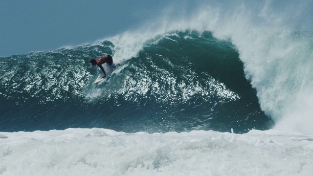 酷酷的冲浪者从冲浪板上撞向溅起的桶波。视频下载