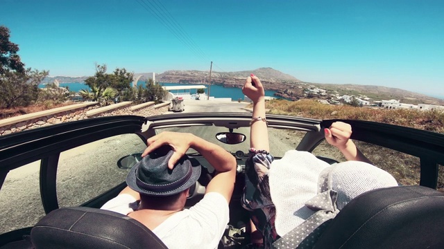 一对夫妇开车经过希腊圣托里尼岛的海岸视频素材