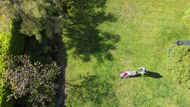 夏天的下午，十几岁的男孩在后院割草视频素材