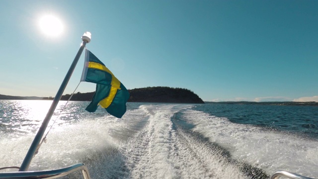 从一艘挂着瑞典国旗的摩托艇上的后视图视频下载