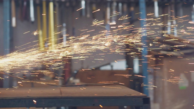 当工业工人在仓库里用圆锯切割金属时，圆锯发出火花视频素材