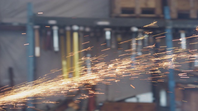 当成熟的人在工业仓库里用圆锯切割金属时，火花四溅视频素材