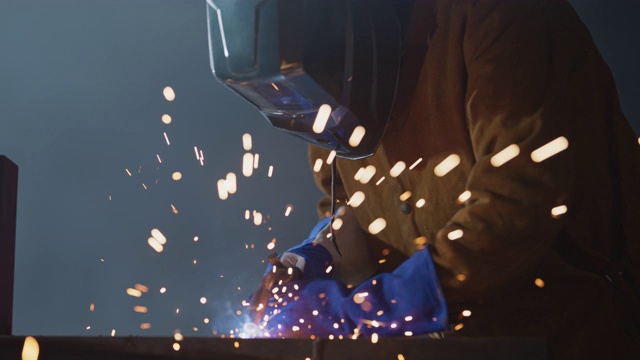 SLO MO CU火花飞溅，熟练的焊工使用火炬连接金属件视频下载