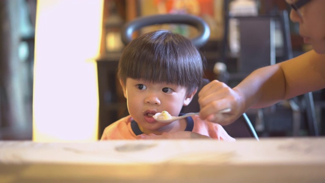 亚洲母亲在日本餐馆喂她的儿子。视频素材