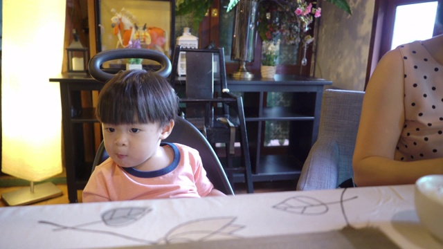 亚洲母亲和她的儿子一起在一家日本餐馆吃饭。视频素材