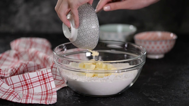 烘焙原料的准备。女人们用手把黄油和面粉加到碗里视频素材