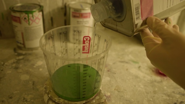 液体倒入绿色量杯视频素材