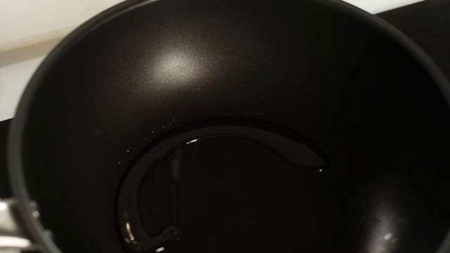 专业厨师将橄榄油倒入加热的铁平底锅中。视频素材