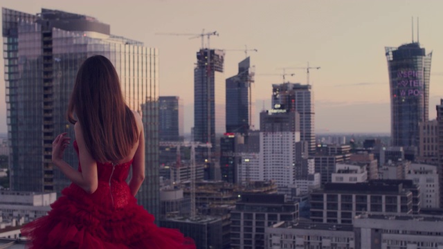 屋顶上的诱惑女人。穿着漂亮的红色裙子。欣赏的观点视频下载