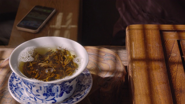 近端倒热水以盖丸冲泡乌龙茶。用开水倒碗泡茶是一种传统的茶道。视频素材