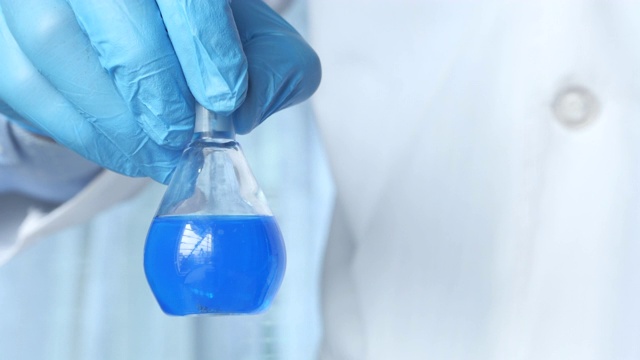 科学家戴着蓝手套在实验室做化学测试视频素材
