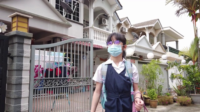 一个戴着口罩上学的亚洲中国小女孩走出家门成为新常态视频下载