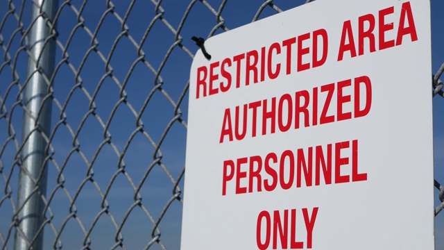 限制区域，授权人员在美国签字。红色字母，金属围栏上的远离警告，美国边境标志。没有侵入通知意味着违规者将被美国法律起诉视频素材