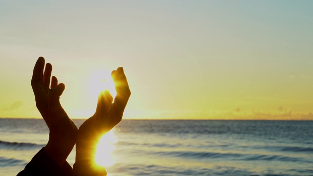 在日落背景下，女人双手祈祷上帝的祝福视频素材