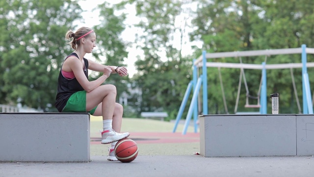 女子篮球运动员与看运动手表视频素材