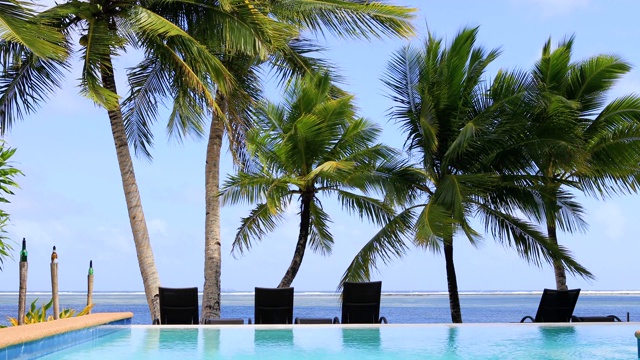 豪华度假酒店的游泳池。我们可以在4K的背景中看到地平线上的海洋视频素材