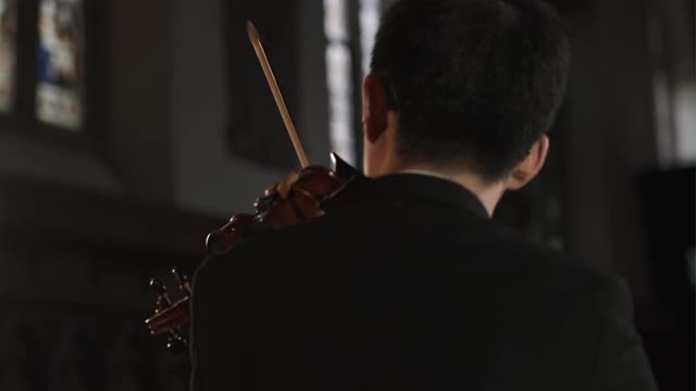两个男小提琴家表演的平移后视图视频素材