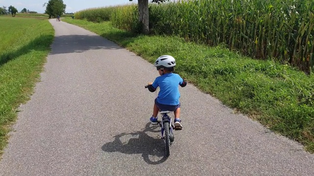 小孩(4岁)在户外(乡村)学习骑自行车视频素材