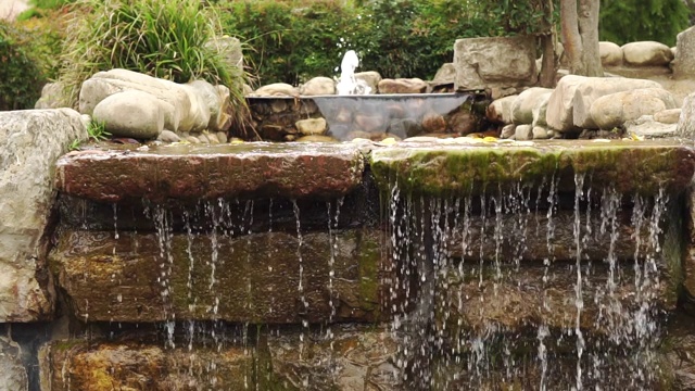 装饰瀑布用天然石材和一个小喷泉。视频素材
