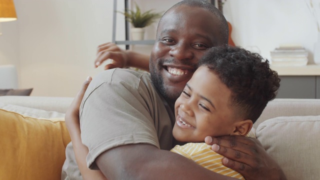爱的美国黑人爸爸和儿子拥抱和微笑的肖像视频素材