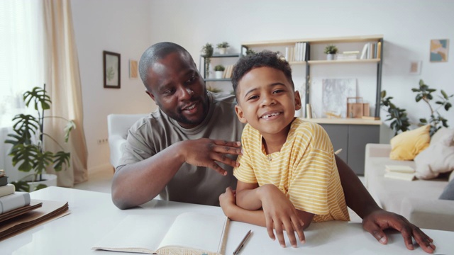快乐的美国黑人爸爸和儿子在家里通过网络电话交谈视频素材