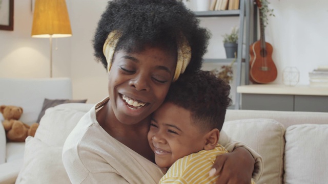 快乐的美国黑人妈妈和儿子的肖像拥抱和微笑视频素材