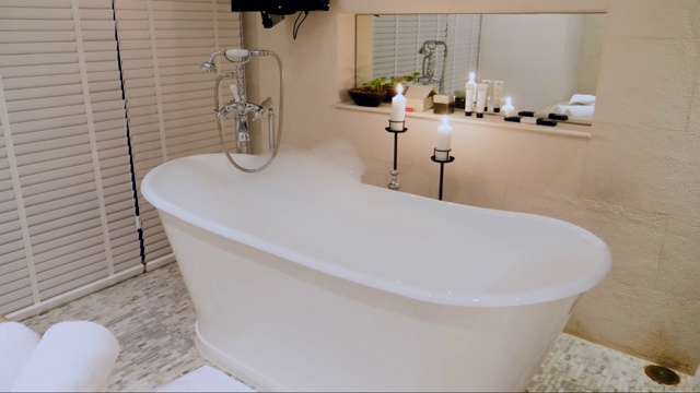 空浴缸与泡沫和泡沫在豪华浴室蜡烛视频素材